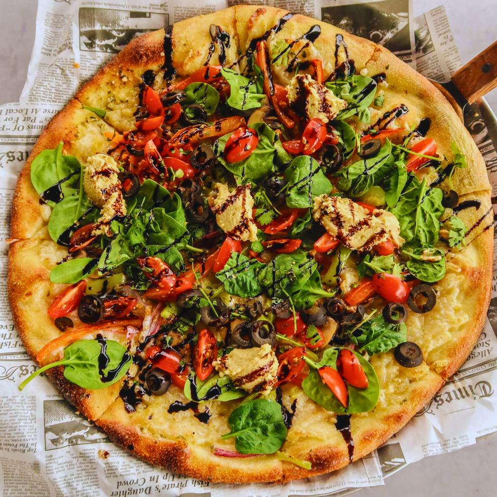 La “Hummus Pizza” lleva vegetales frescos, vinagre balsámico y cilantrillo. Suministrada