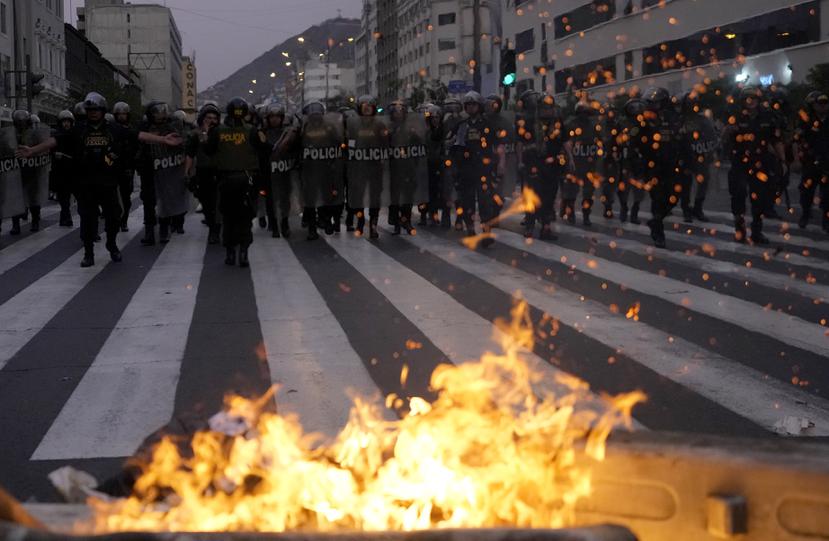 La policía se acerca a una barricada en llamas instalada por partidarios del derrocado presidente Pedro Castillo durante enfrentamientos con la policía, en Lima, Perú, el jueves 8 de diciembre de 2022.