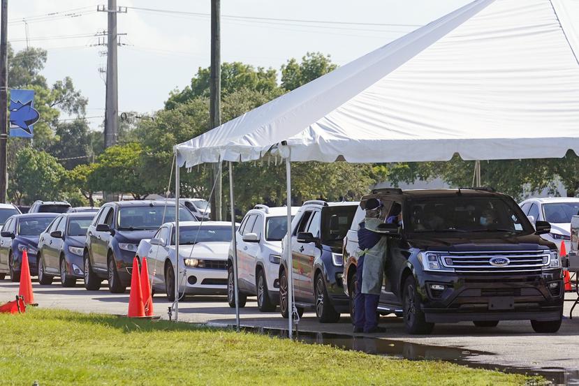 Automóviles hacen fila en el sitio de pruebas diagnósticas de COVID-19 en las instalaciones de la universidad Miami Dade College North.
