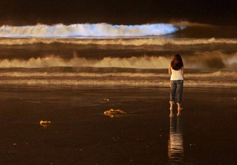 Una joven observa la brillantez en el mar . (AP)