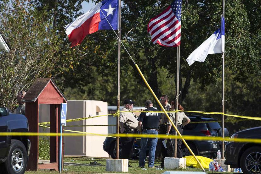 Efectivos de la policía se ubican al lado del cuerpo de una de las víctimas fatales (cubierta con un plástico amarillo) del tiroteo en una iglesia en Sutherland Springs en Texas. (Austin American-Statesman vía AP / Nick Wagner)