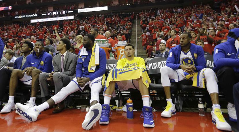 Caras largas se observan en el banco de los Warriors, quienes fueron derrotados anoche por los Rockets de Houston. (AP)