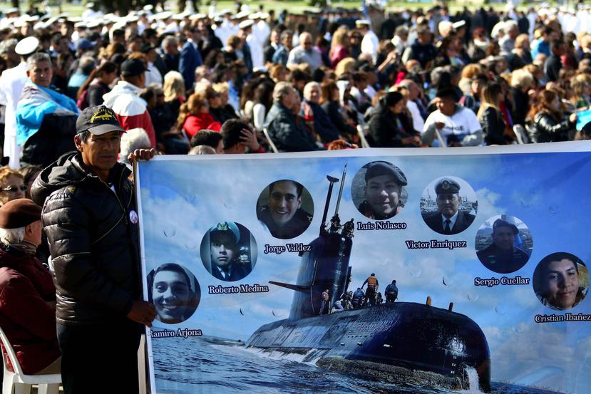 Un hombre sostiene una pancarta con imágenes de algunos tripulantes del submarino argentino ARA San Juan. (EFE / Eduardo López)