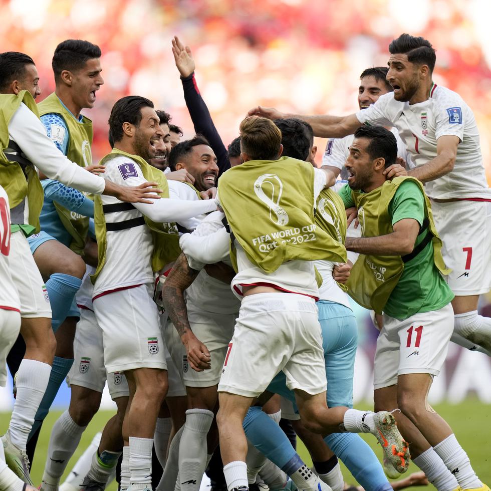 Jugadores de Irán celebran con euforia luego de que Rouzbeh Cheshmi (oculto) anotara el primer gol en los minutos añadidos después que los primeros 90 minutos se agotaron con un empate 0-0 con Gales.