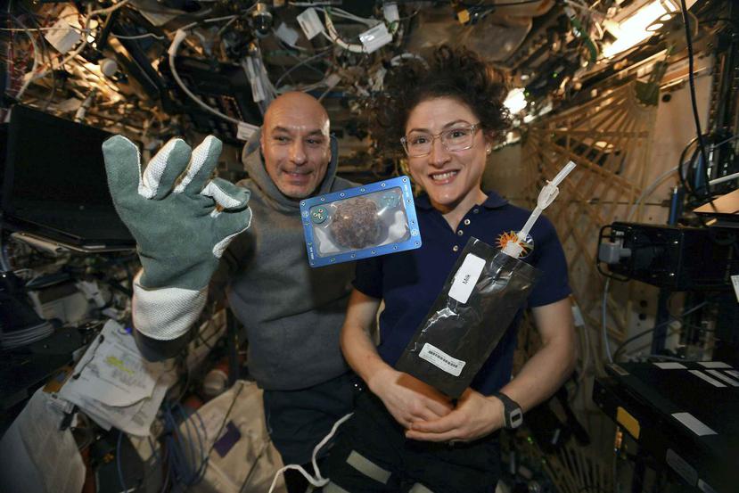 La astronauta estadounidense Christina Koch y el astronauta italiano Luca Parmitano con unas galletas cocidas en la Estación Espacial Internacional. (AP)