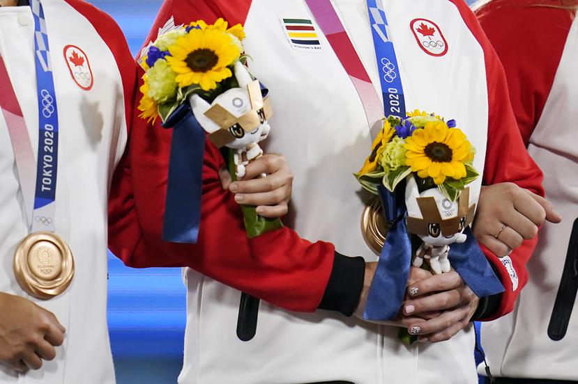 Atletas de Canadá cargan con los ramos de flores que se otorgan a los ganadores de medallas en Tokio.