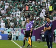 Uno de los árbitros levanta la pizarra mostrando los primeros ocho minutos añadidos después de concluidos los 90 reglamentarios del partidos entre Argentina y Arabia Saudita.