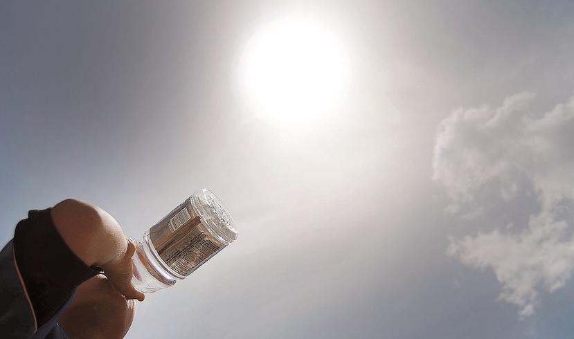 Un hombre bebe agua para aliviar el calor del día. (GFR Media)