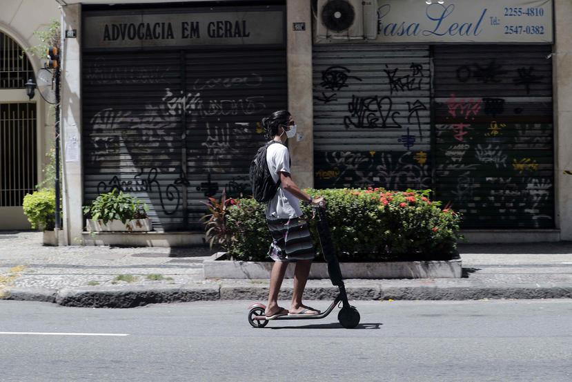 Un joven monta patineta frente a locales cerrados en el barrio de Copacabana debido a las medidas restrictivas para evitar la propagación del coronavirus este martes, en Río de Janeiro. (Agencia EFE)