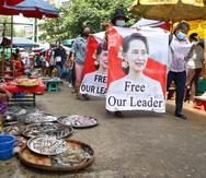 Manifestantes en contra del golpe de Estado marchan por un mercado con imágenes de la lideresa derrocada de Myanmar, Aung San Suu Kyi, en el municipio de Kamayut en Yangón.