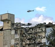 Un helicóptero del Cuerpo de Bomberos de Miami-Dade sobrevuela el área donde está ubicado el condominio que colapsó parcialmente esta madrugada.