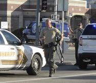 Fotografía de archivo de un policía corriendo hacia un vehículo en San Bernardino, California.