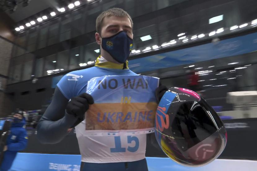 En imagen del video, el ucraniano Vladyslav Heraskevych sostiene un letrero con la leyenda "No a la guerra en Ucrania" tras terminar su competencia en el skeleton masculino en los Juegos Olímpicos de Pekín, este viernes.