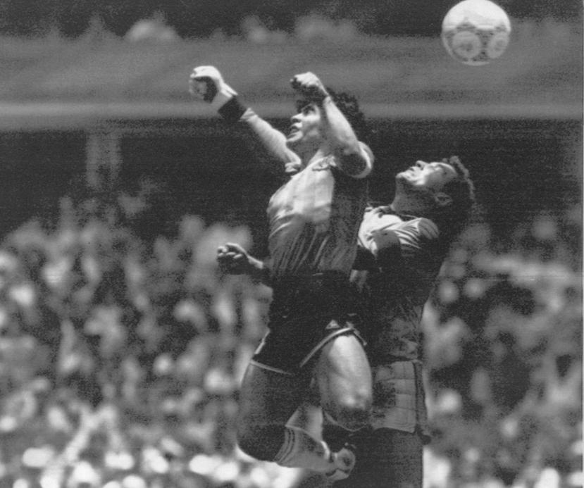 El argentino Diego Maradona (izquierda) supera en el salto al portero inglés Peter Shilton y anota el primero de sus dos goles en un partido de cuartos de final de la Copa del Mundo en Ciudad de México, 22 de junio de 1986.
