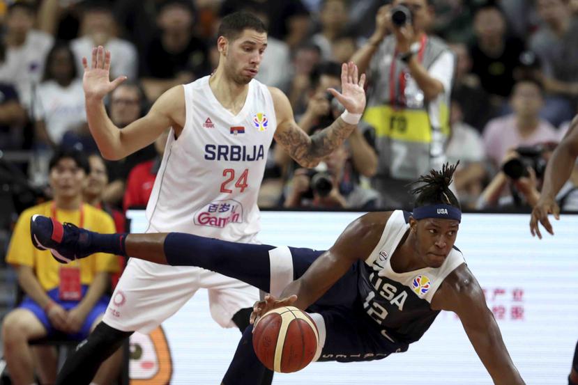 El jugador de Estados Unidos Myles Turner se cae cerca del serbio Stefan Jovic en un playoff de consolación de la Copa del Mundo de baloncesto en Dongguan, en el sur de China. (AP)