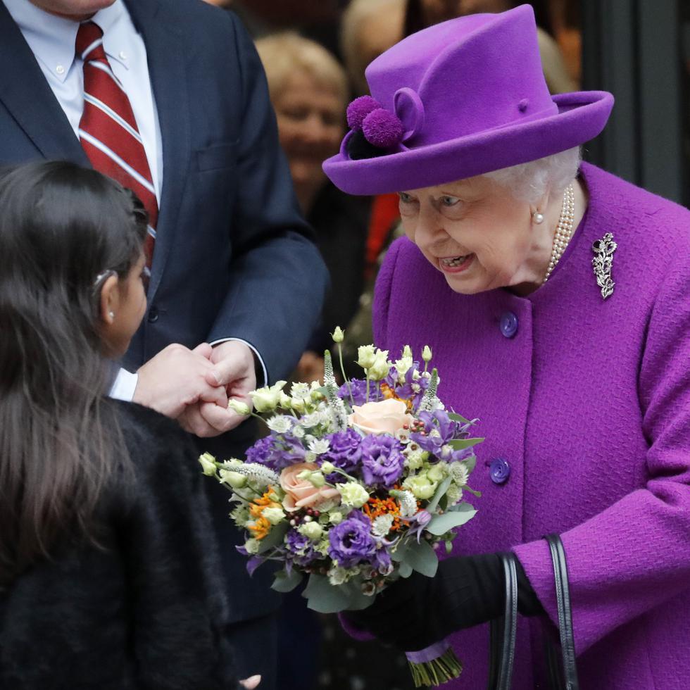 ARCHIVO – La reina Isabel II de Gran Bretaña recibe flores al salir tras la inauguración oficial en las nuevas instalaciones de los Hospitales Reales de Otorrinolaringología y Salud Dental Eastman en Londres el 19 de febrero de 2020.(Foto AP/Frank Augstein, archivo)