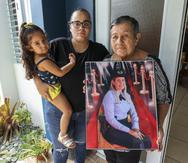 Suleika Bahamonde muestra una foto de su hija, la agente Brenda Pérez Bahamonde. La acompaña la hija de la oficial asesinada, Nicole Colón Pérez, quien carga a su sobrina Lexuanys , de 6 años.