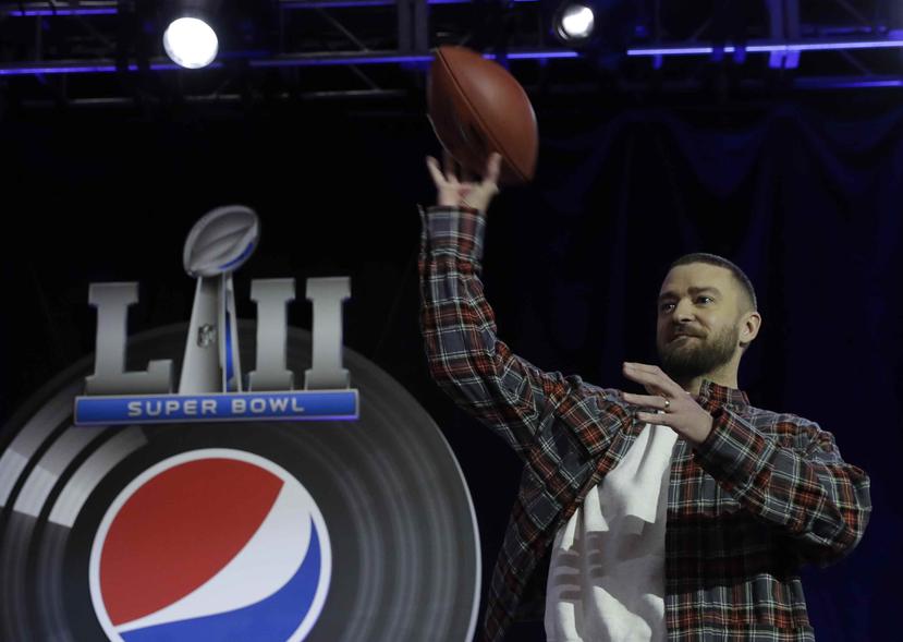 Justin Timberlake lanza una pelota de fútbol americano durante la conferencia de prensa de su presentación este domingo en el Super Bowl. (AP)