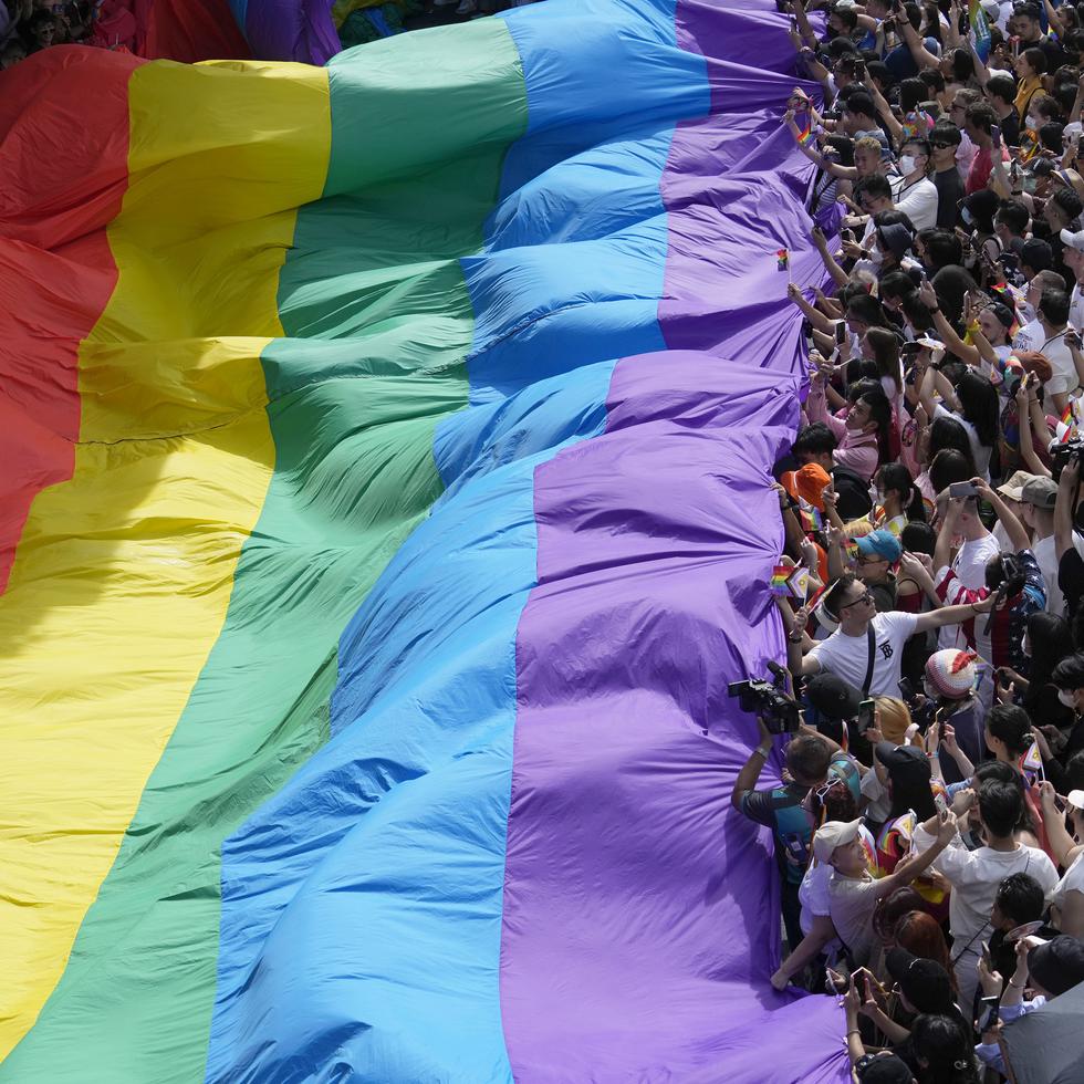 En esta imagen de archivo, participantes en el desfile del Orgullo Gay sostienen una bandera con los colores del arcoíris, símbolo de la comunidad, en Bangkok, Tailandia, el 4 de junio de 2023.