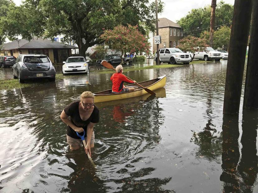 Personas realizan trabajos de limpieza después de una intensa tormenta en el vecindario Broadmoor de Nueva Orleans. (AP)


