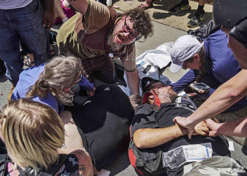 En esta foto del 12 de agosto, socorristas trabajan con víctimas en la escena en la que un hombre arrasó con un automóvil una multitud de personas que se había reunido para protestar en contra de una manifestación supremacista blanca. (Archivo / AP)