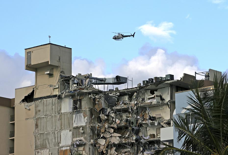 Un helicóptero del Cuerpo de Bomberos de Miami-Dade sobrevuela el área donde está ubicado el condominio que colapsó parcialmente esta madrugada.