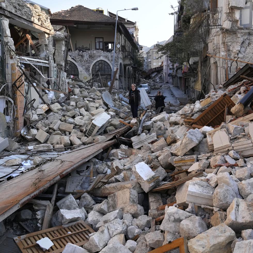 Una mujer turca sobre los escombros de las casas patrimoniales que se destruyeron durante el devastador terremoto, en la antigua ciudad de Antakya, en el sur de Turquía, el lunes 13 de febrero de 2023.