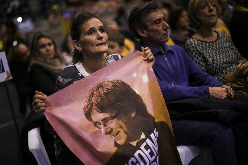 Una mujer sostiene una bandera con la cara del expresidente catalán Carles Puigdemont (AP).