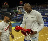 El campeón mundial de boxeo Robeisy Ramírez le entrega unos guantes firmados a Ysmael Romero.