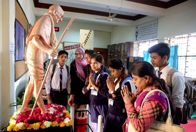 Varias personas muestran sus respetos ante una estatua de Mahatma Gandhi durante la celebración del Día de los Mártires con motivo del 70 aniversario de su asesinato (EFE/ Sanjeev Gupta).