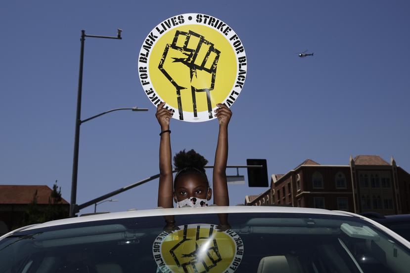 Foto de archivo del 20 de julio de 2020 de Audrey Reed, de 8 años, sosteniendo un letrero a través del techo corredizo de un automóvil durante un mitin en Los Ángeles.