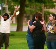 La gente reza y se consuela durante una vigilia por las víctimas que murieron en la Escuela Primaria Robb, en Uvalde, Texas, el 24 de mayo de 2022.
