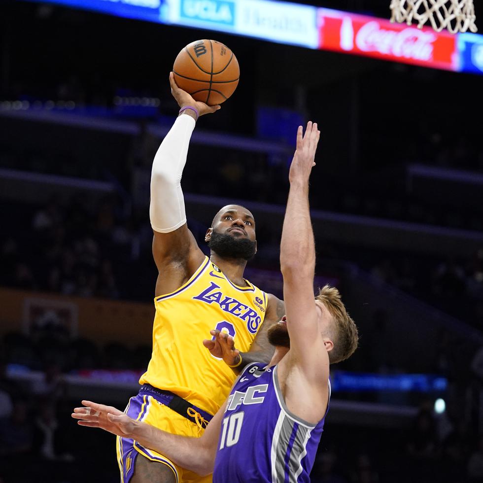 LeBron James, de los Lakers, intenta encestar frente a Domantas Sabonis, de los Kings de Sacramento en un juego de pretemporada. La campaña arranca el martes y si mantiene su promedio de 27 puntos por juego podría romper el récord de la NBA en enero.