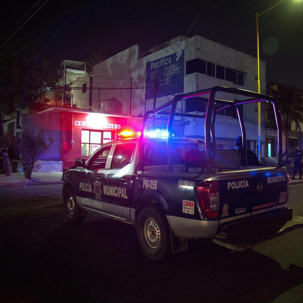 Policías municipales vigilan la zona donde fue asesinado el periodista Heber López Vásquez en Salina Cruz, estado de Oaxaca (México).