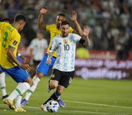 Lionel Messi escapa con el balón de la defensa de Brasil durante el partido del martes.