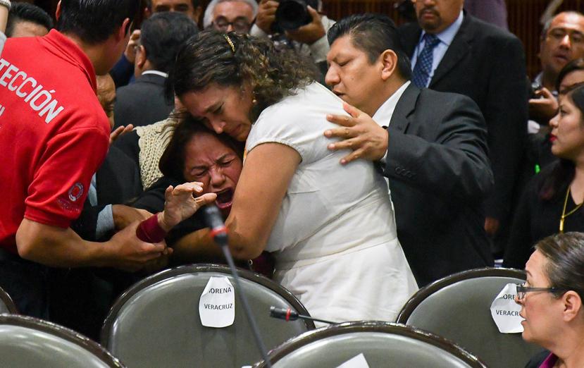 Legisladores consuelan a la diputada Carmen Medel Palma, luego de que recibiera la noticia de que su hija había sido asesinada. (EFE)