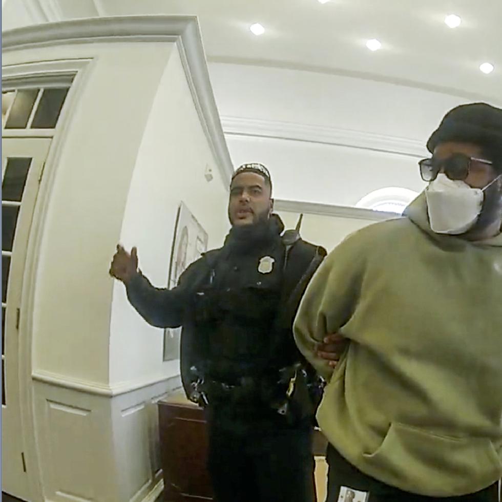 Un policía detiene al director de "Black Panther" Ryan Coogler en una sucursal de Bank of America en Atlanta en esta imagen de enero de 2022 tomada de un video de la Policía de Atlanta. Coogler fue esposado brevemente luego que una empleada del banco lo confundió con un asaltante.