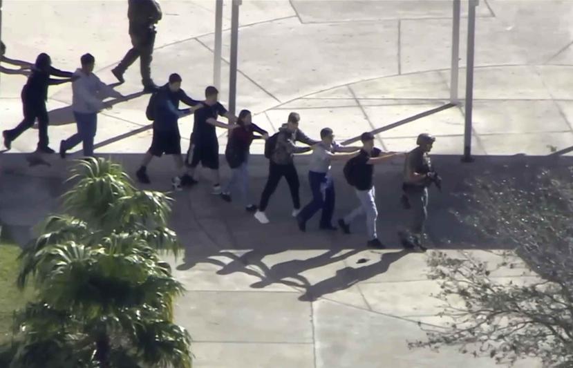 Estudiantes salen de la escuela con las manos elevadas luego de que se reportara un tiroteo. (AP)