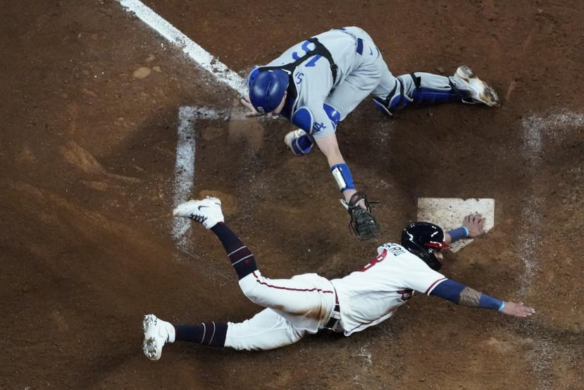El cátcher de los Dodgers de Los Ángeles, Will Smith, no logra tocar a Eddie Rosario, de los Braves de Atlanta, en el plato en el segundo juego de la Serie de Campeonato de la Liga Nacional el domingo.