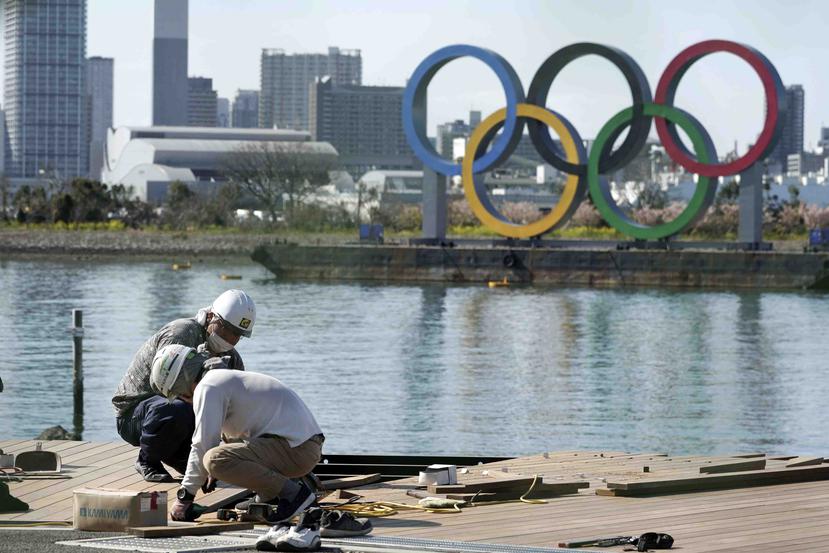 Trabajadores continúan con su faena en una localidad en el distrito de Odaiba en Tokio, ciudad donde en menos de cinco meses se supone que se celebren las Olimpiadas. (AP / Eugene Hoshiko)
