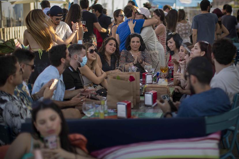 Múltiples personas disfrutan un rato de esparcimiento el domingo 21 de junio de 2020 en un bar en Barcelona, España. (AP)