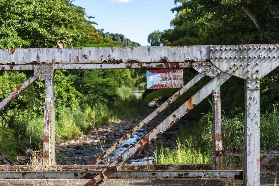 Un puente antiguo con la bandera de Puerto Rico de camino hacia Charco Blanco, también conocido como el charco “El Hippie”, en Naguabo.