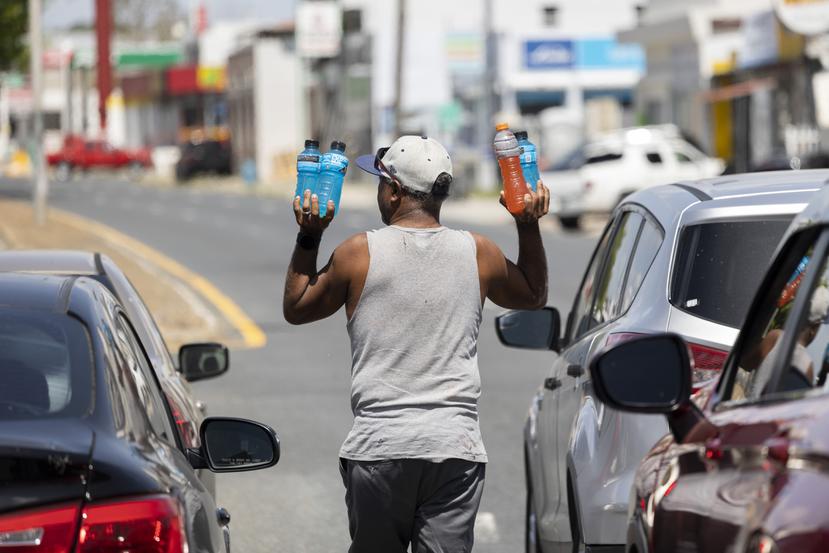 Don Olmos, vendedor ambulante por más de 15 años, vende productos hidratantes en un semáforo de la avenida Piñero, durante un aviso de calor extremo.