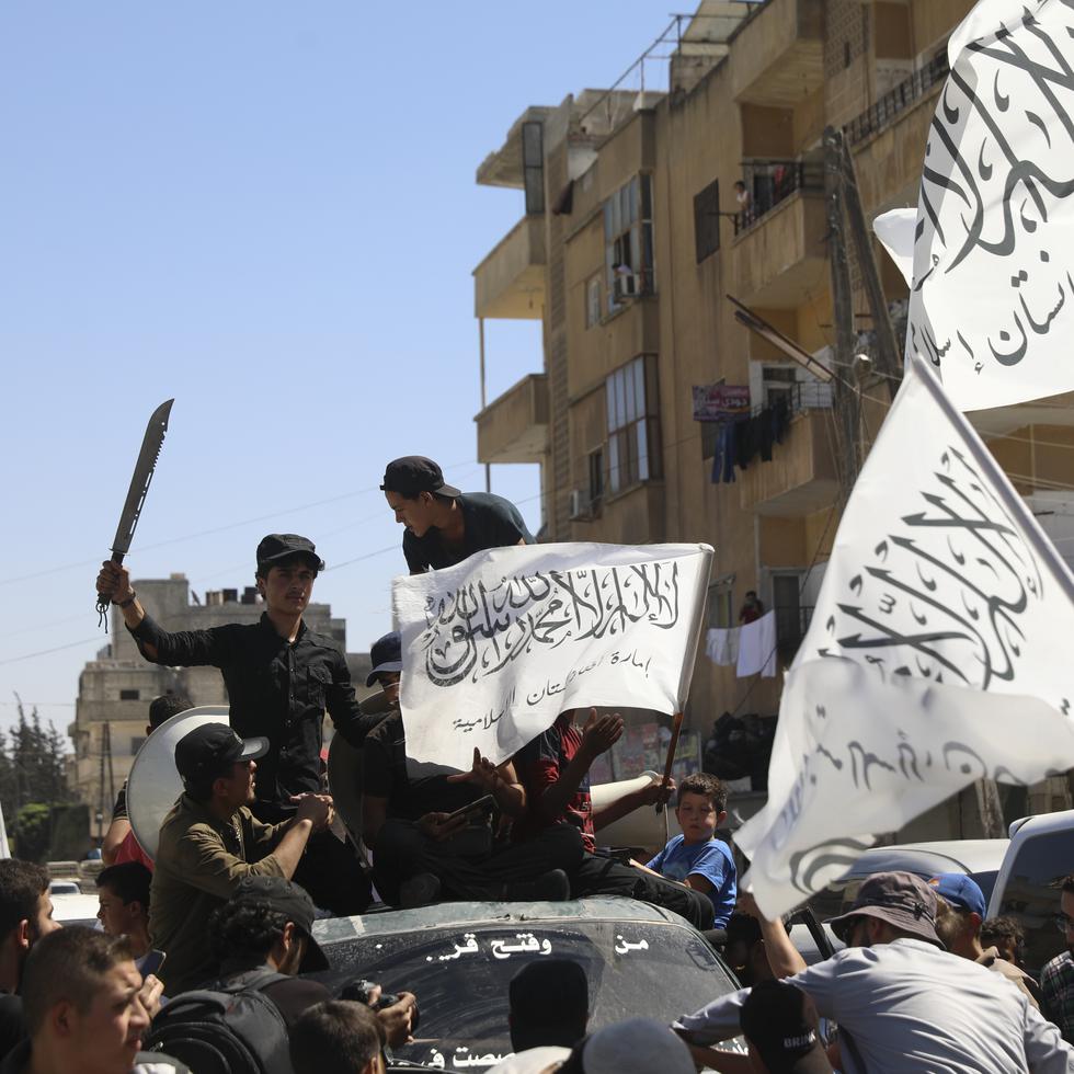 Members of the Hay'at Tahrir al-Sham, a Sunni Islamist militant group, wave the Taliban flags as they celebrate the Taliban takeover of Afghanistan, in the city of Idlib, Friday, Aug. 20, 2021.  The Taliban’s takeover of Afghanistan is giving radical Islamic groups from Syria and the Gaza Strip to Pakistan and West Africa reason to celebrate. They see America's violence-marred exit from Afghanistan as an opportunity to regroup and reassert their ideology.  (AP Photo/Ghaith Alsayed)