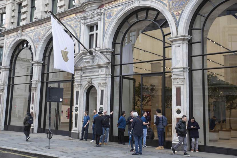 Empleados de la tienda de Apple informan a los clientes sobre el cierre de la sucursal durante dos semanas, en Regent Street de Londres. (AP)