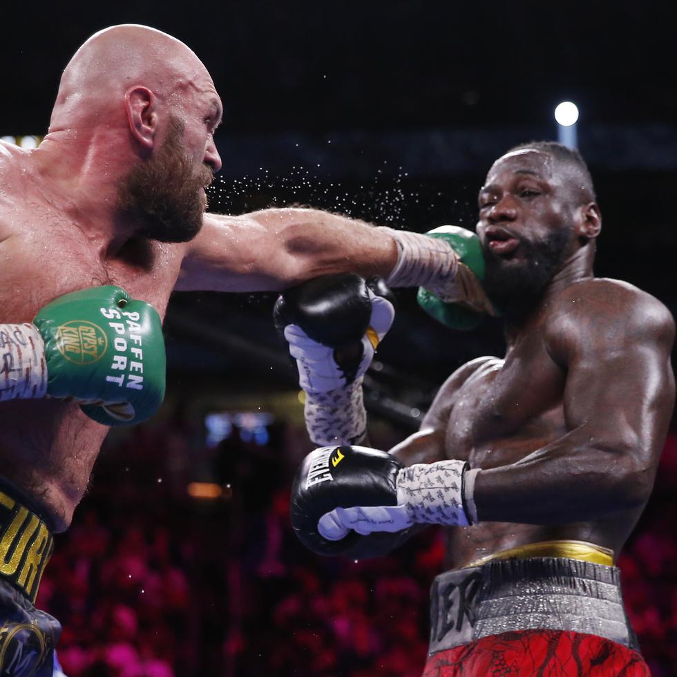 Tyson Fury conecta una izquierda a un agotado Deontay Wilder en los asaltos finales de su tercer combate titular.