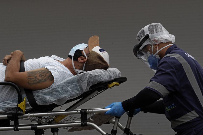 Un trabajador de salud lleva a un paciente a un hospital público de Brasilia, el jueves 29 de abril de 2021. (AP Foto/Eraldo Peres)