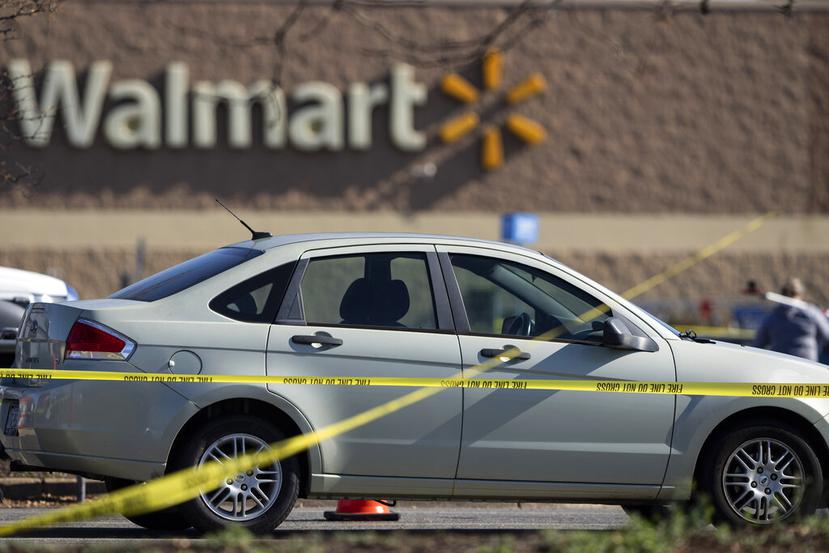 Una cinta para acordonar el sitio de un delito rodea un automóvil luego de un tiroteo a mansalva en una tienda Walmart el miércoles 23 de noviembre de 2022, en Chesapeake, Virginia. (AP Foto/Alex Brandon)