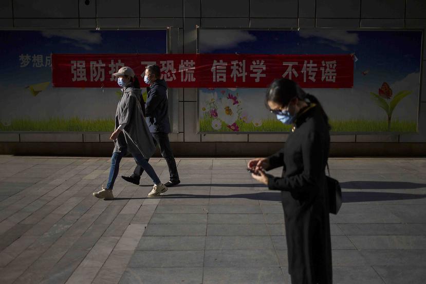 Ciudadanos caminan utilizando mascarillas en una carretera de Beijing. (AP)