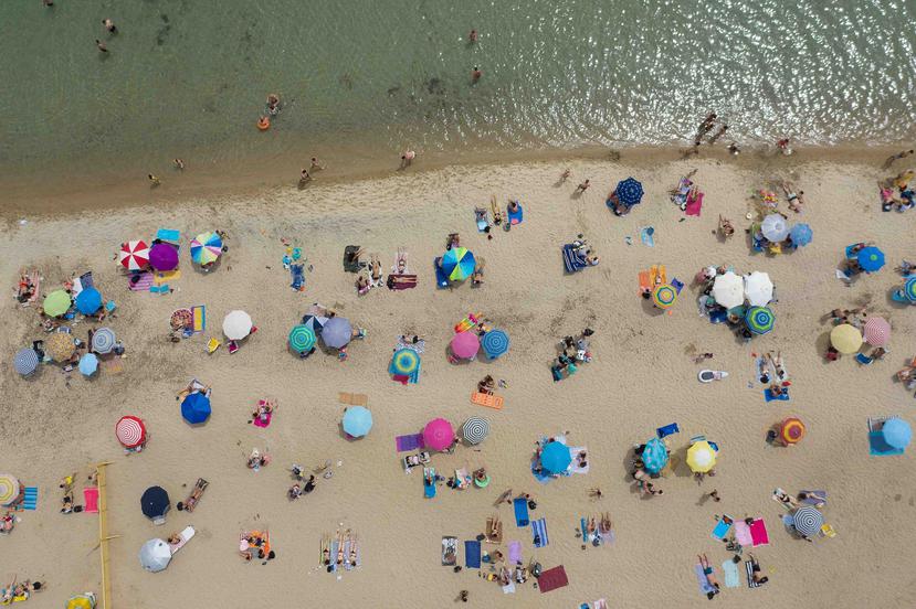En algunos sitios drones sobrevolaron la costa con altavoces en los que se advertía a los bañistas a mantener las distancias seguras. (Agencia EFE)